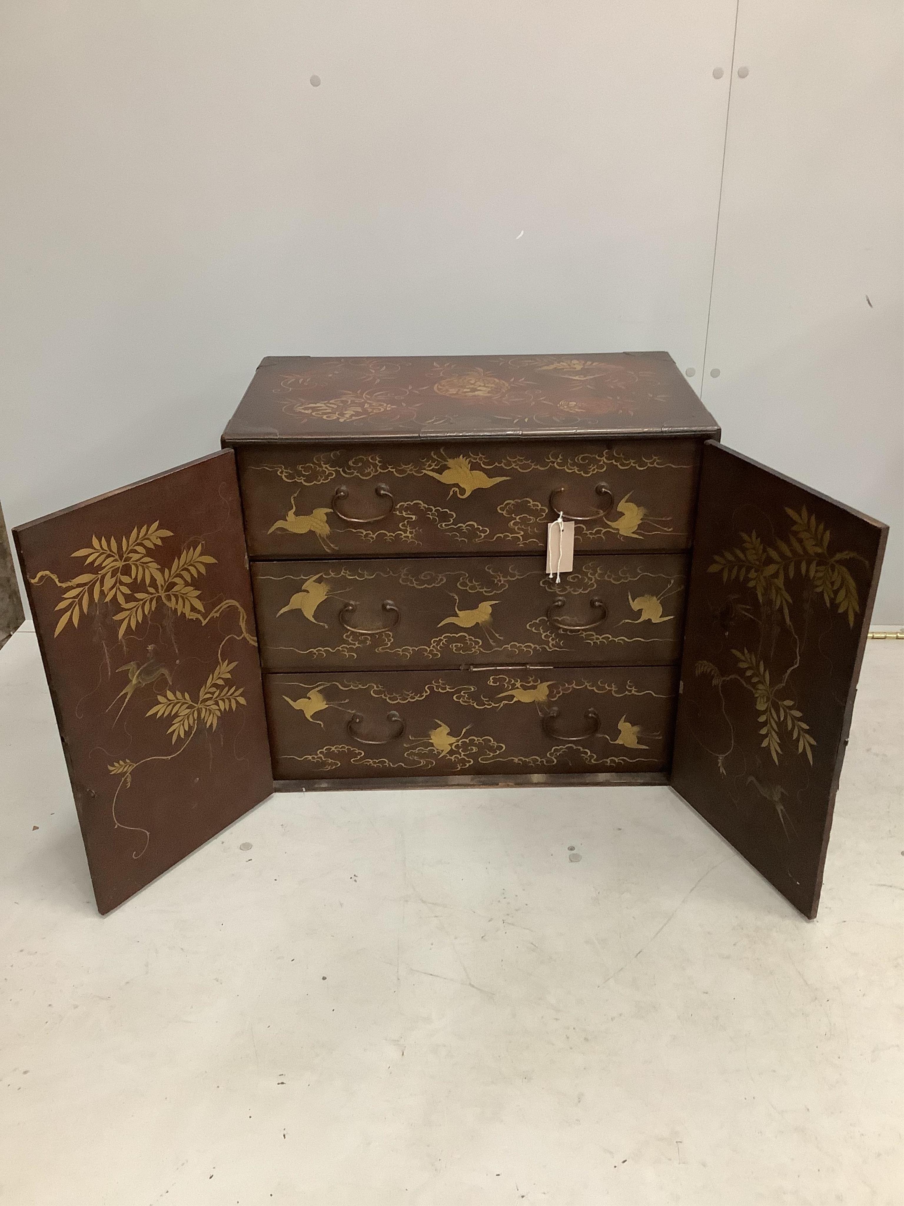 A 19th century Japanese gilt decorated lacquer table cabinet with two doors enclosing three drawers, width 61cm, depth 36cm, height 54cm. Condition - fair to good